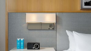 A hotel room with a bed, a bedside table with a radio, and a wall-mounted light fixture. - 2 Connecting Suites at a 4.5⭐️ Hotel (Chicago)