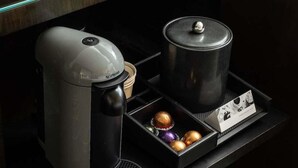 A coffee maker, a black pot, and a box with chocolates on a table. - 2 Connecting Suites at a 4.5⭐️ Hotel (Chicago)