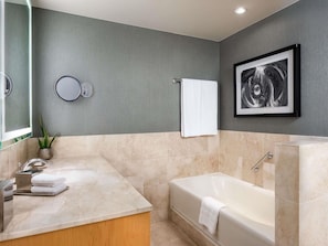 A modern bathroom with a marble sink, a bathtub, and a framed artwork on the wall. - 2 Connecting Suites at a 4.5⭐️ Hotel (Chicago)