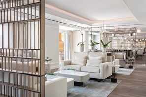 A modern living room with a sofa, coffee table, and decorative plants.