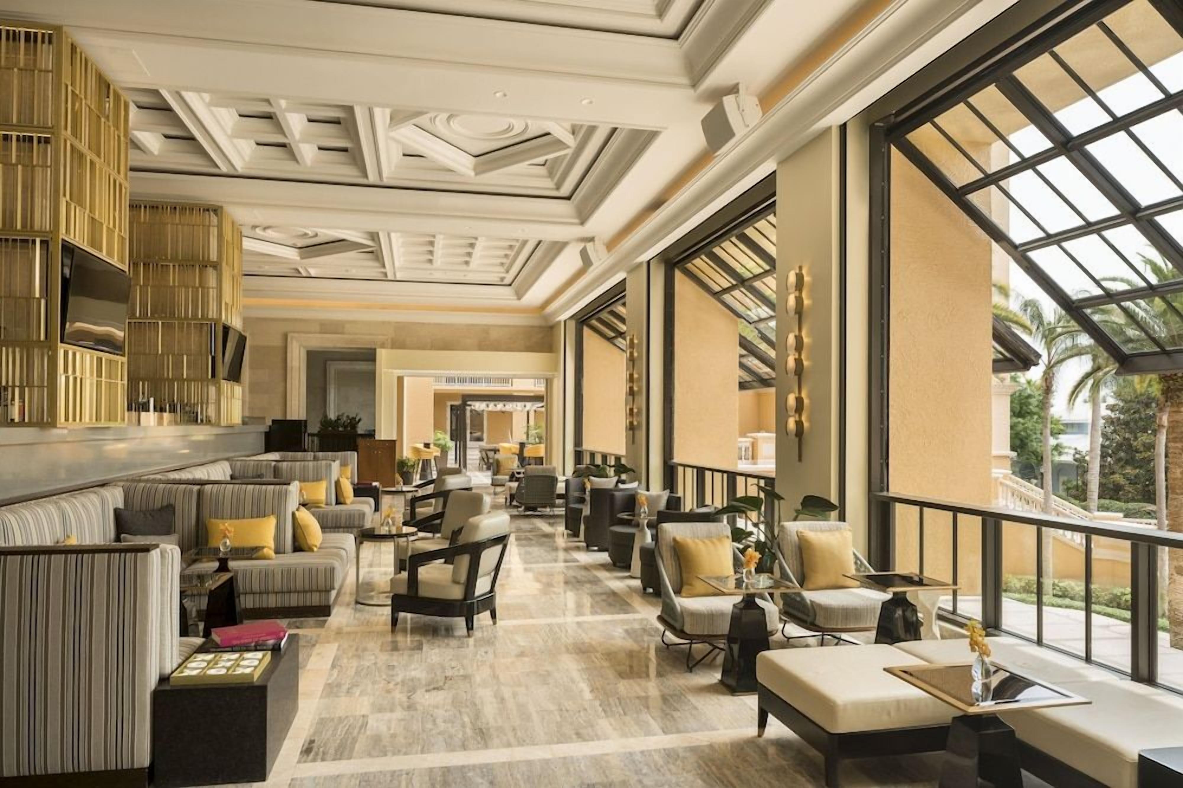 Un'ampia hall con soffitto alto, grandi finestre e diverse opzioni di seduta.