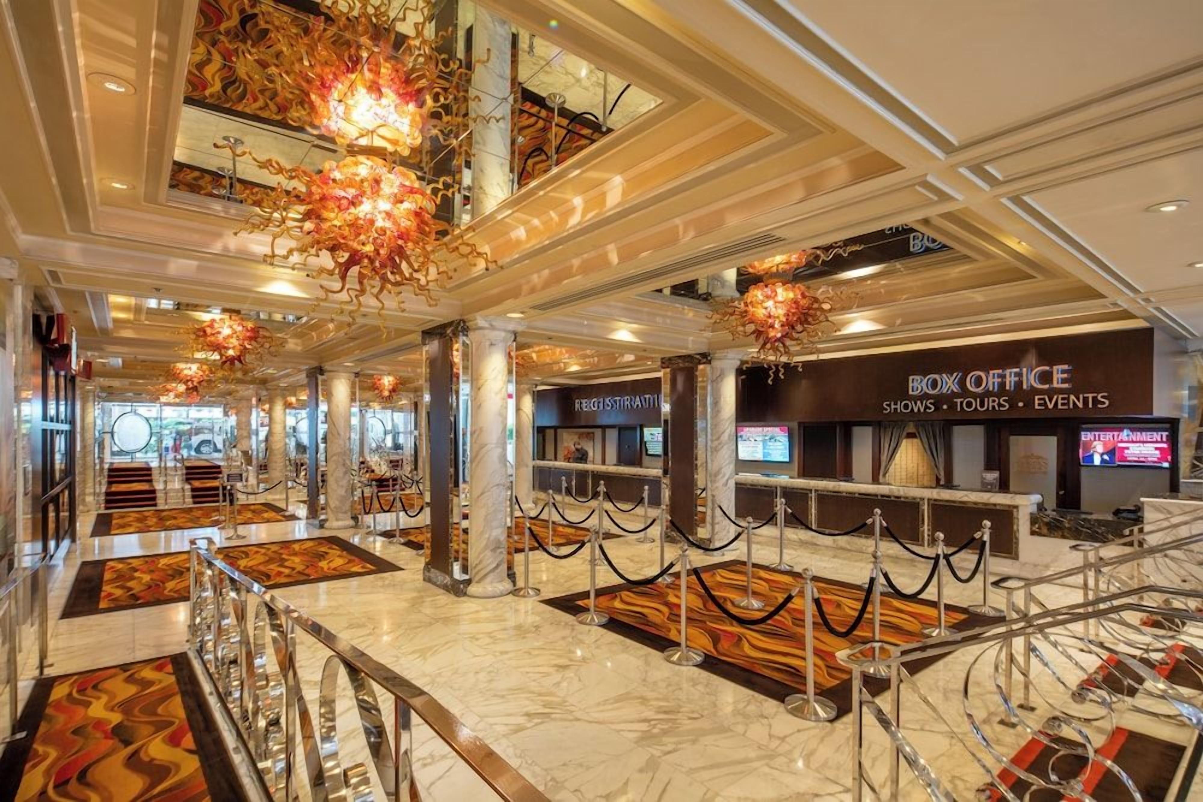 A hotel lobby with marble flooring, a registration desk, and a Box Office for shows, tours, and events.