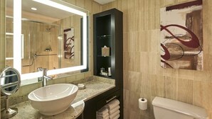 Un baño moderno con un espejo grande, un lavabo sobre encimera, un mueble negro y un inodoro.