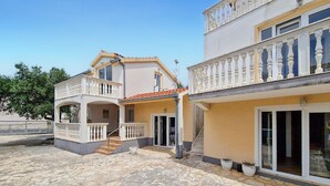 Un bâtiment à deux étages doté d’un balcon et d’une cour intérieure en pierre.