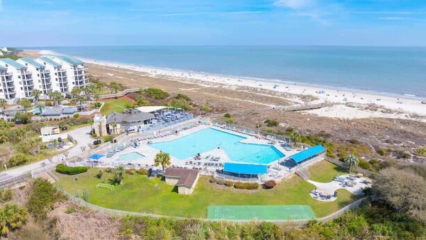 Ein Resort mit großem Schwimmbad, Zugang zum Strand und einem Tennisplatz.