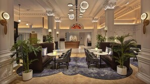 A spacious lobby with a central reception desk, multiple seating areas, and decorative lighting. - 2 Connecting Suites at a 4⭐️ Hotel (New York)