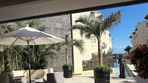 Un espace patio aménagé avec du mobilier d’extérieur, une statue et une vue sur l’océan.