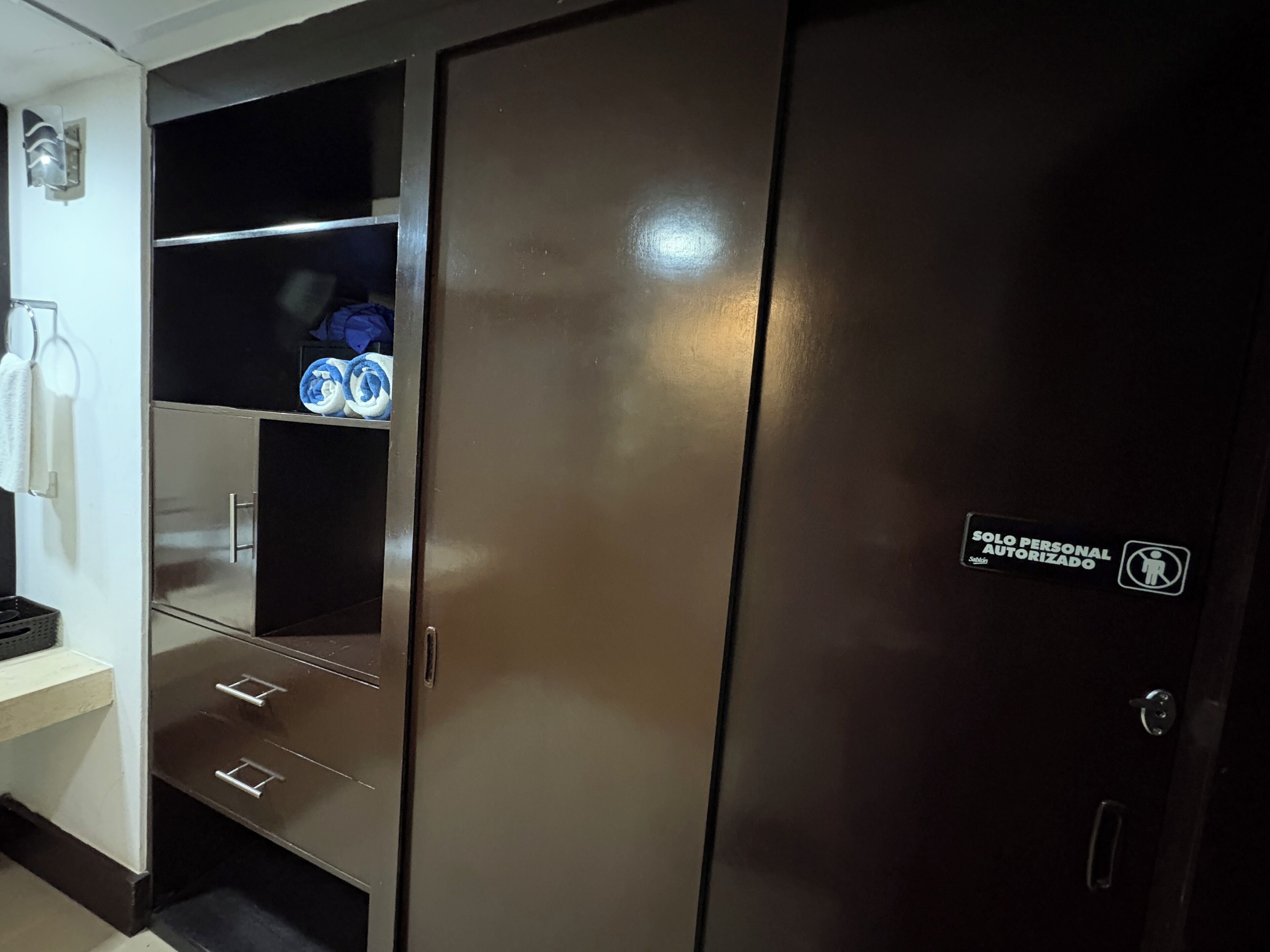 A wardrobe with a 'Solo Personal Autorizado' sign, indicating private access.