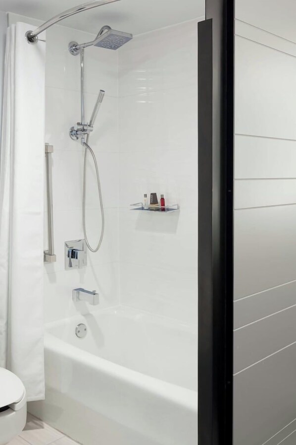 Une salle de bain moderne avec une douche à parois de verre, une baignoire blanche et des toilettes.
