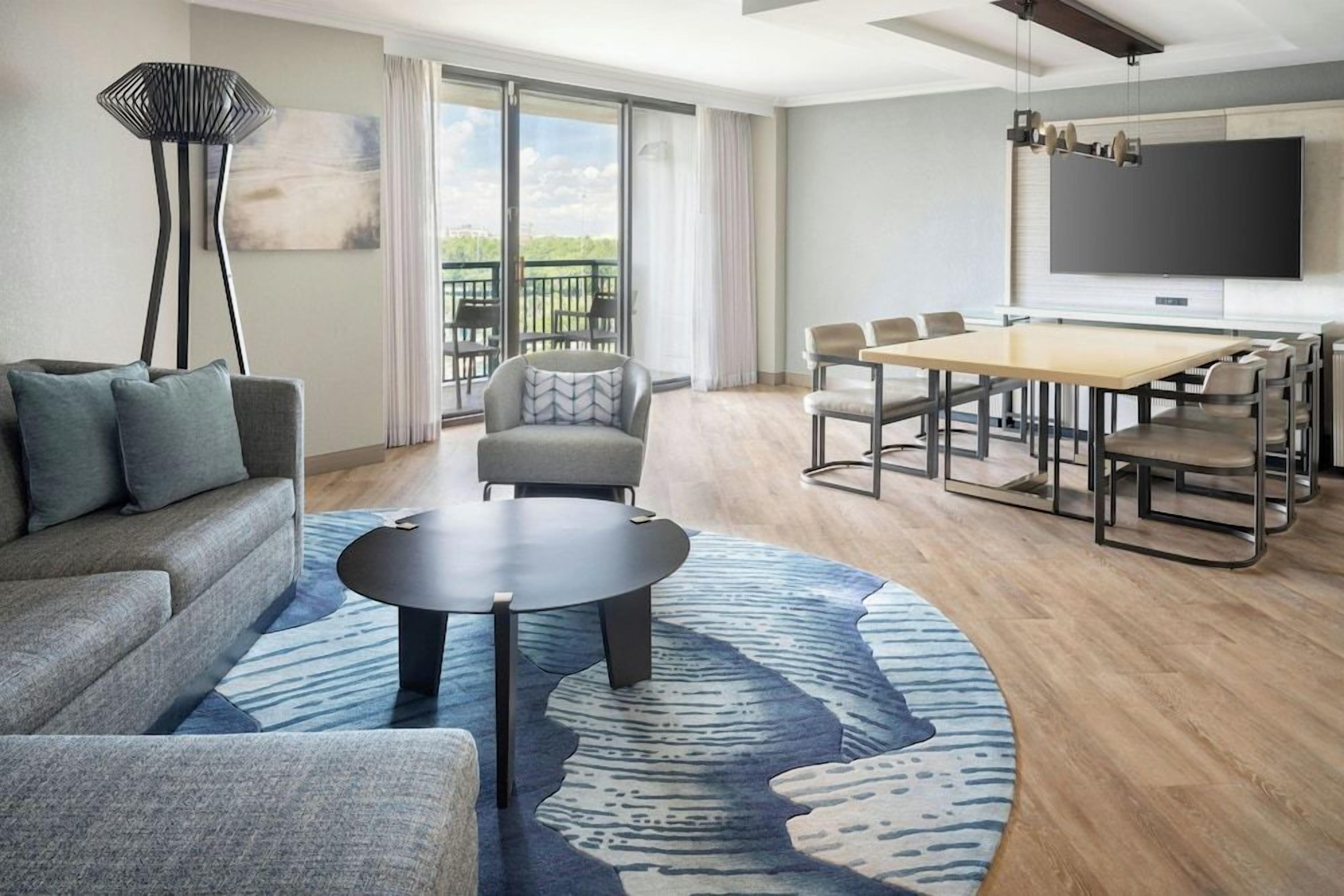 Un salon moderne comprenant un canapé, une table basse ronde et un coin repas avec une table et des chaises.