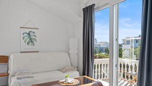 Un salon moderne avec un canapé, une table basse et un balcon doté d’une balustrade.