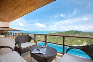 A balcony with wicker furniture, a pool, and a view of the landscape. - Baan Grand Vista - Panoramic Sea View (Koh Samui)
