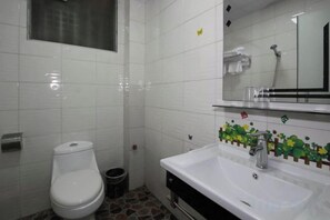 A bathroom with a toilet, sink, and mirror. - Huaxia Boutique Inn (Yangshuo West Street Branch) (Yangshuo)