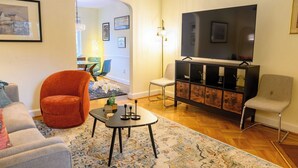 Un salon comprenant un canapé, un fauteuil, un téléviseur et un meuble de divertissement.