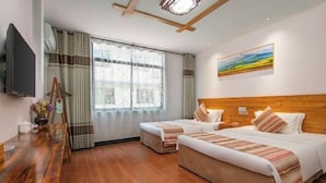 A hotel room with two beds, a wooden headboard, a painting on the wall, a TV on the left, and a wooden floor. - Benyuan Hostel (Wuyishan)