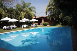 A swimming pool with white umbrellas and chairs, surrounded by palm trees. - Quinta Olivos!!, UN Espacio Para TU Descanso...!! (Mor.)