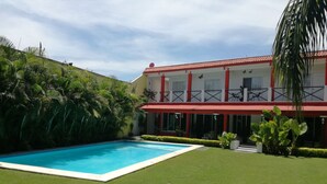 A pool with a red-roofed building in the background. - Quinta Olivos!!, UN Espacio Para TU Descanso...!! (Mor.)
