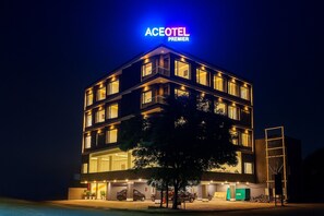 A multi-story hotel with a prominent neon sign reading "ACEOTEL PREMIER" at the top. The building features multiple balconies and large windows. - Aceotel Premier Vijay Nagar (Indore)