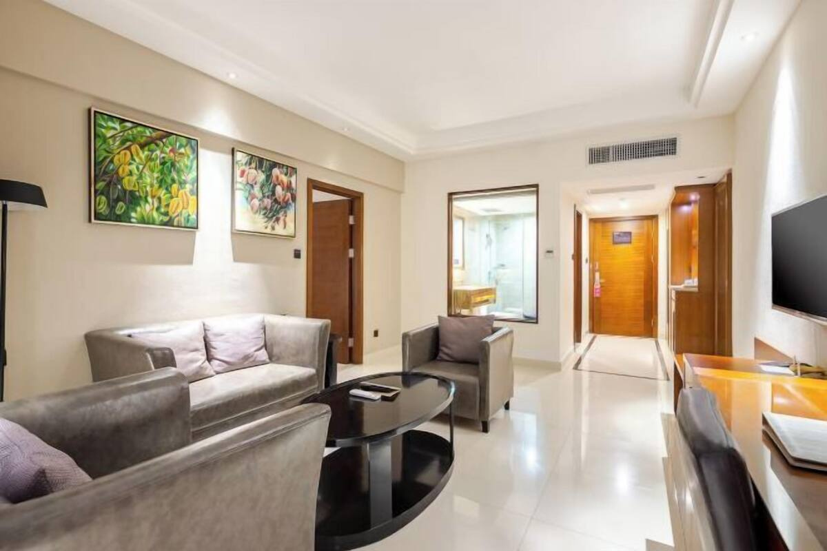 Un hall d’hôtel moderne avec un canapé, des fauteuils, une table basse et des œuvres d’art accrochées aux murs.