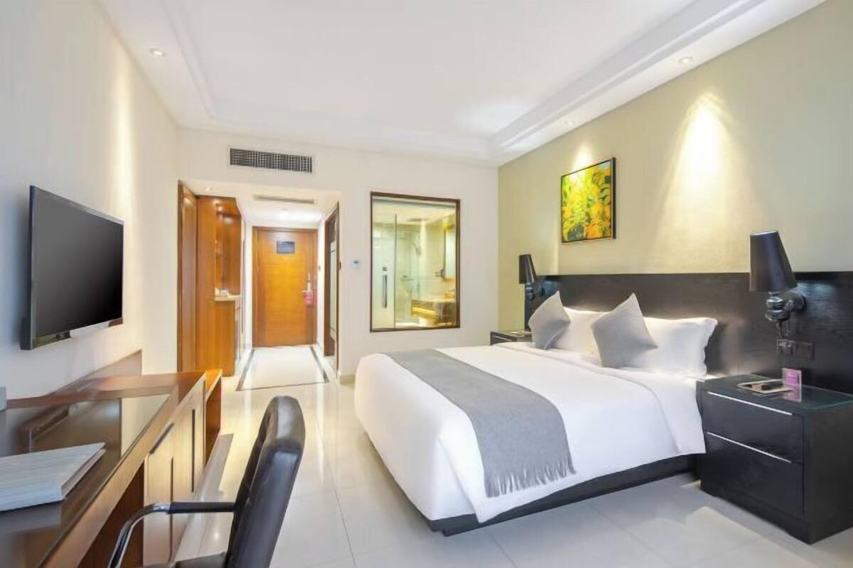 Une chambre d’hôtel équipée d’un lit, d’une table de chevet, d’une télévision, d’un bureau et d’une chaise.