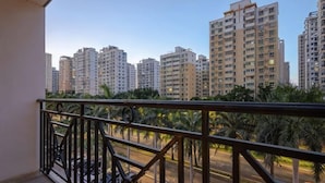 A balcony with a view of high-rise buildings and palm trees. - Haikou Manyue Hot Spring Hotel (Hainan University Branch) (Haikou)