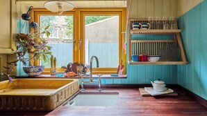 A kitchen with a sink, a window with a view, and a shelf with dishes. - Charming East London Apartment (London)