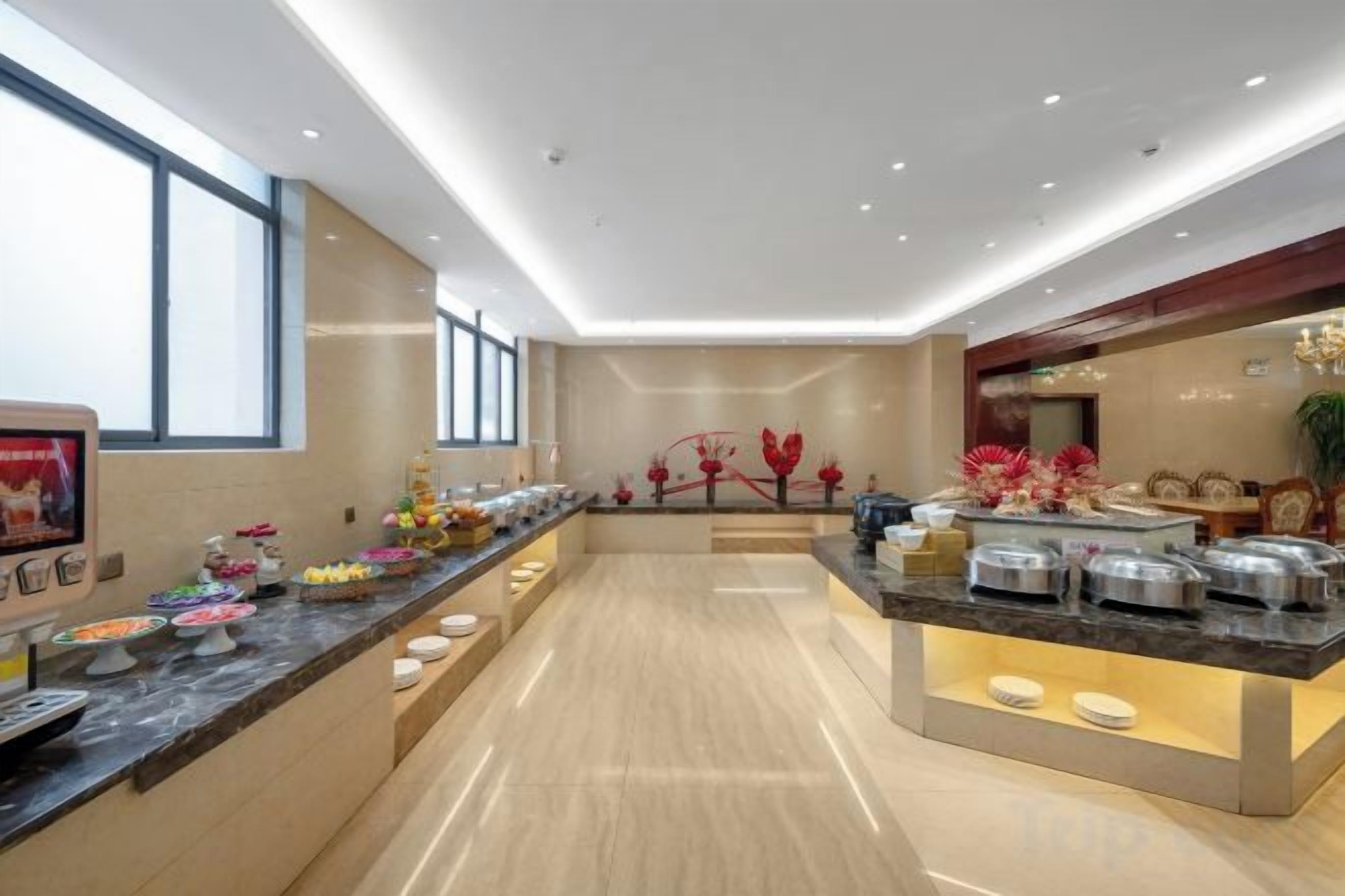 A modern hotel lobby with a long reception counter, a large window, and a decorative wall.
