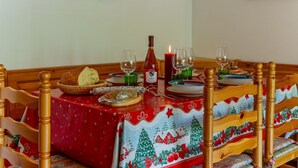 Et spisebord dækket med tallerkener, glas, en flaske og et lys.