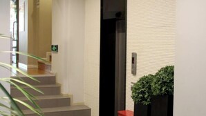 A staircase leading to an elevator in a building with a white brick wall. - Homeinn Hotel (Beijing Sihui Baiziwan Subway Station) (Beijing)