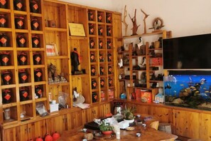 A room with wooden shelving filled with various items, a television, and a fish tank. - Shanghang Binbin Home (Shanghang)