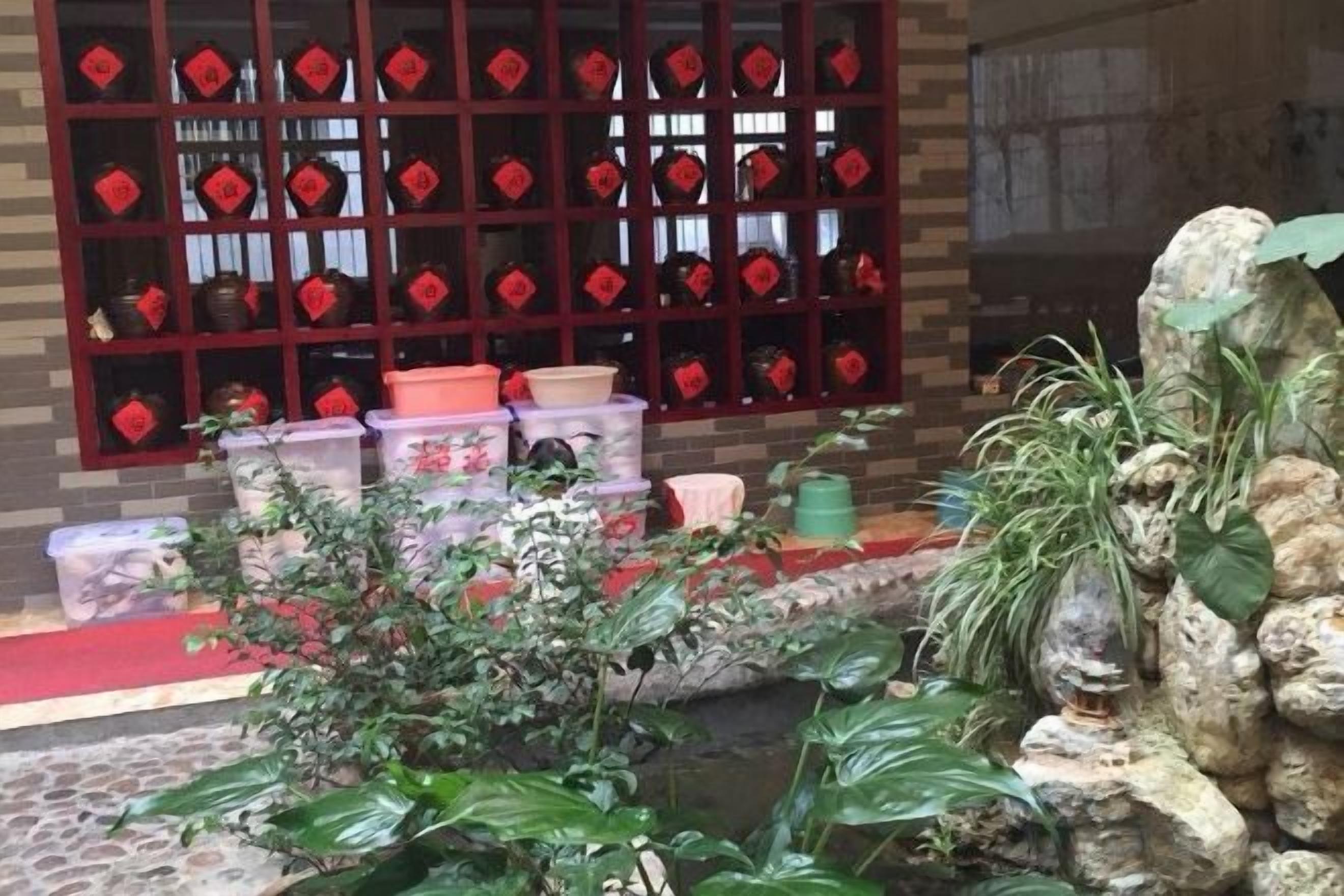 A room with a tiled floor, a red carpet, a window with red decorations, and a small water feature.