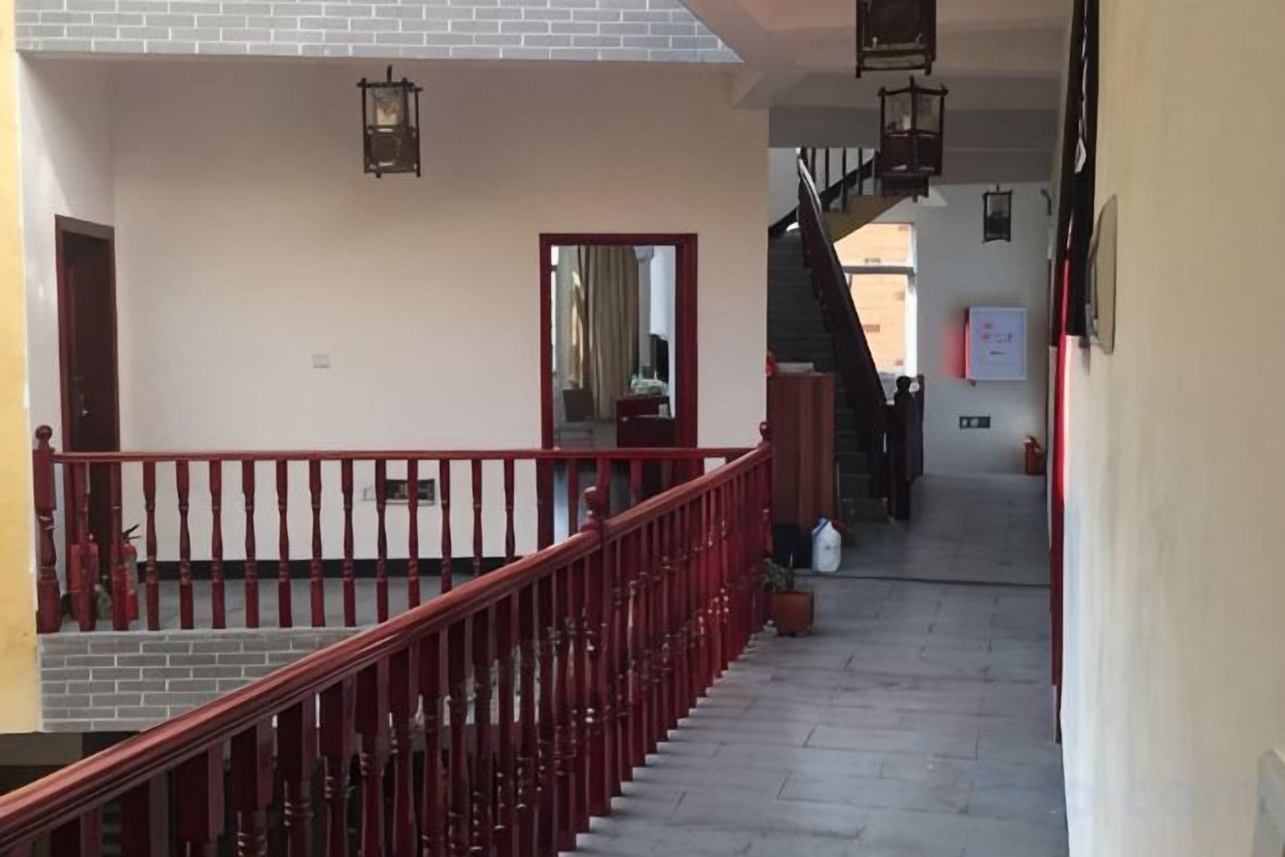 A staircase with a red railing leading to an upper floor.