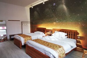 A hotel room with two wooden beds, a starry night mural on the wall, and a small desk with a chair. - Shanghang Binbin Home (Shanghang)
