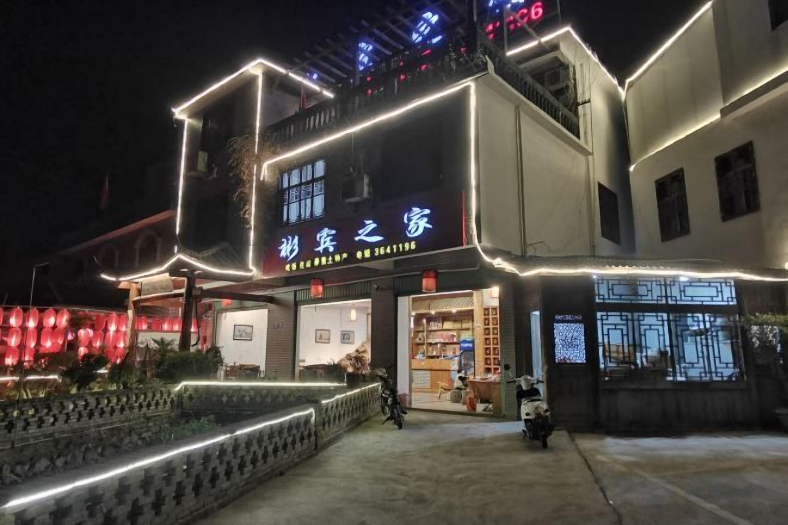 A building with illuminated signage, a gated entrance, and a visible storefront.