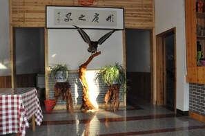 A room with a wooden ceiling, a table with a checkered tablecloth, and a sign with Chinese characters. - Shanghang Binbin Home (Shanghang)