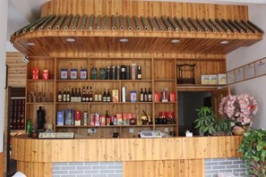A wooden bar area with shelves of bottles and a brick counter. - Shanghang Binbin Home (Shanghang)
