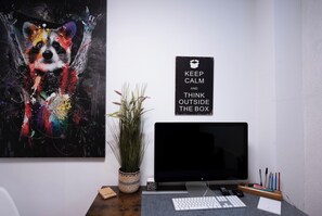 Un bureau avec un ordinateur, un clavier et un panneau d’affichage affichant un message motivant.