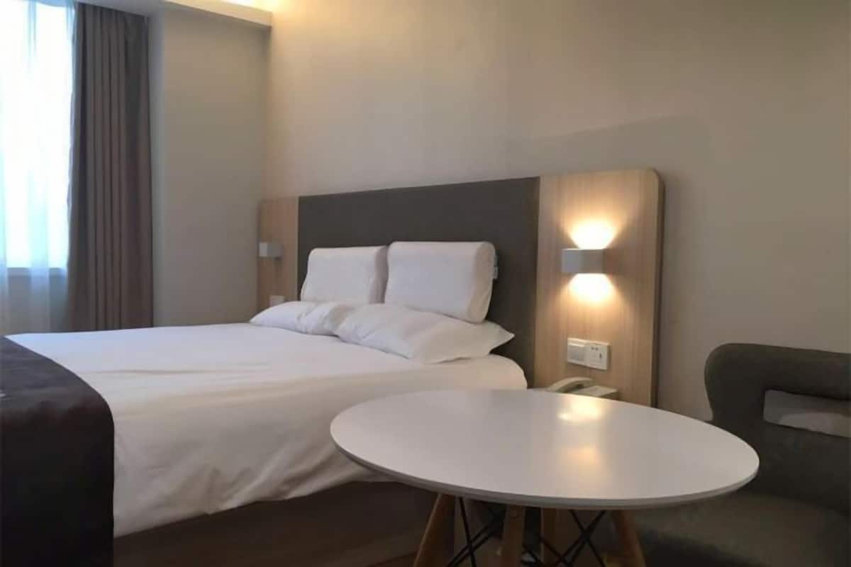 Une chambre d’hôtel avec un grand lit, une table ronde et un canapé.