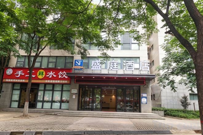 A hotel entrance with a sign for a restaurant on the left.