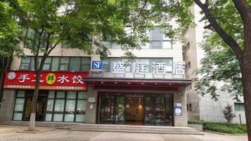 A hotel entrance with a sign for a restaurant on the left.