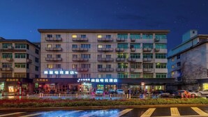 Un hôtel à plusieurs étages doté d’une façade moderne, de nombreux balcons et d’un hall d’entrée bien éclairé.
