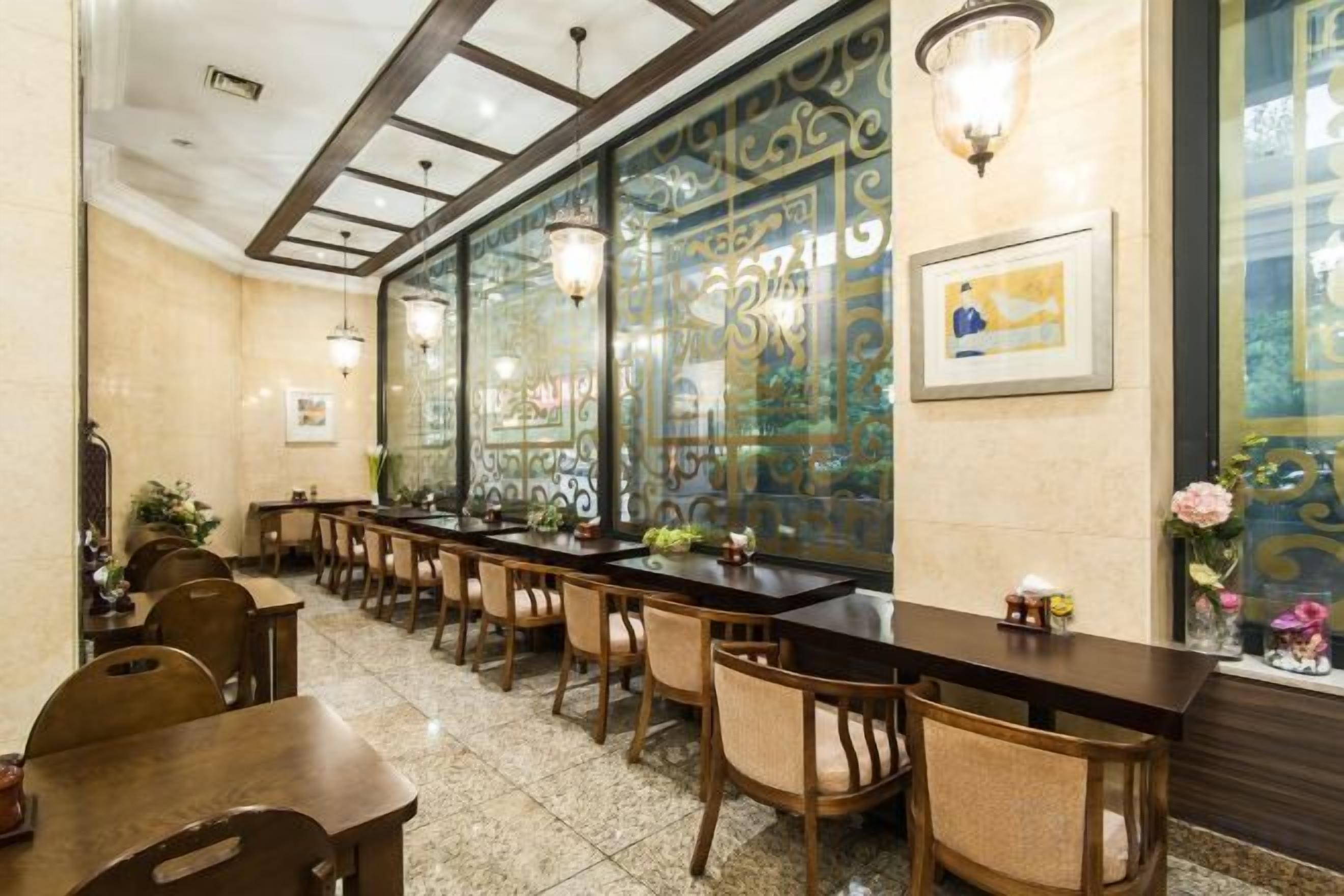 Un restaurante con una barra larga, múltiples sillas y paneles decorativos en la pared.