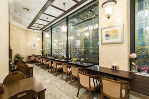 Een restaurant met een lange toonbank, meerdere stoelen en decoratieve wandpanelen.