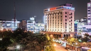 Un hotel de diverses plantes amb una entrada apuntada i cridanera, i senyalització il·luminada.