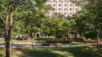 A park with benches, trees, and a building in the background.