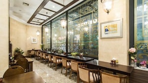 Un restaurant amb una barra llarga, caires de fusta i panells decoratius a la paret.