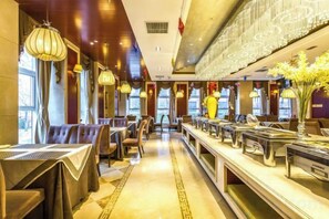 A restaurant with multiple dining tables and chairs, a long counter with a cash register, and hanging light fixtures. - Yangfeng Yiju Hotel (Beijing)