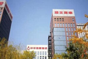 Een gebouw met een bord waarop 'Beijing Hotel' staat en een ander bord met een symbool en onleesbare tekst.