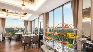 Un espace repas avec un buffet, de grandes fenêtres et une vue sur la ville.