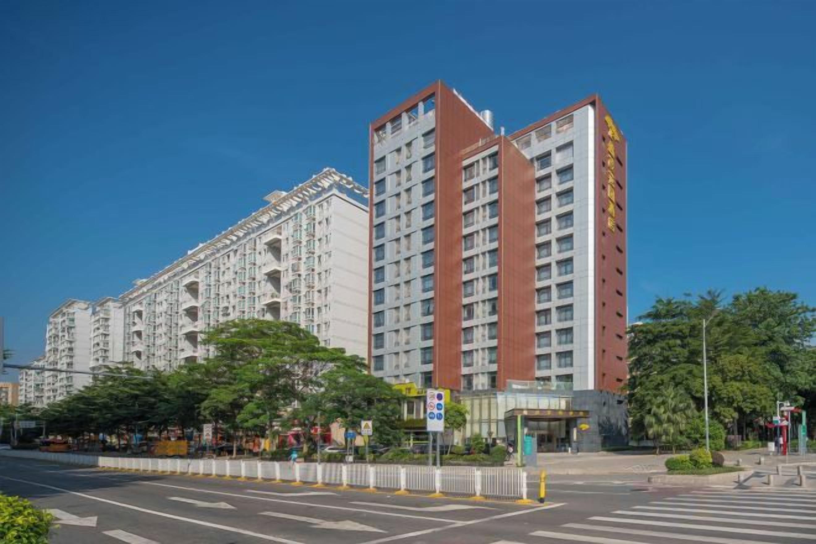 A multi-story hotel with a modern design, featuring a prominent entrance and a large glass facade.